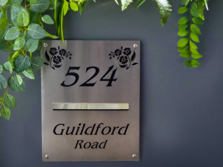 Stylish laser-cut stainless steel letterbox with custom floral design and address.